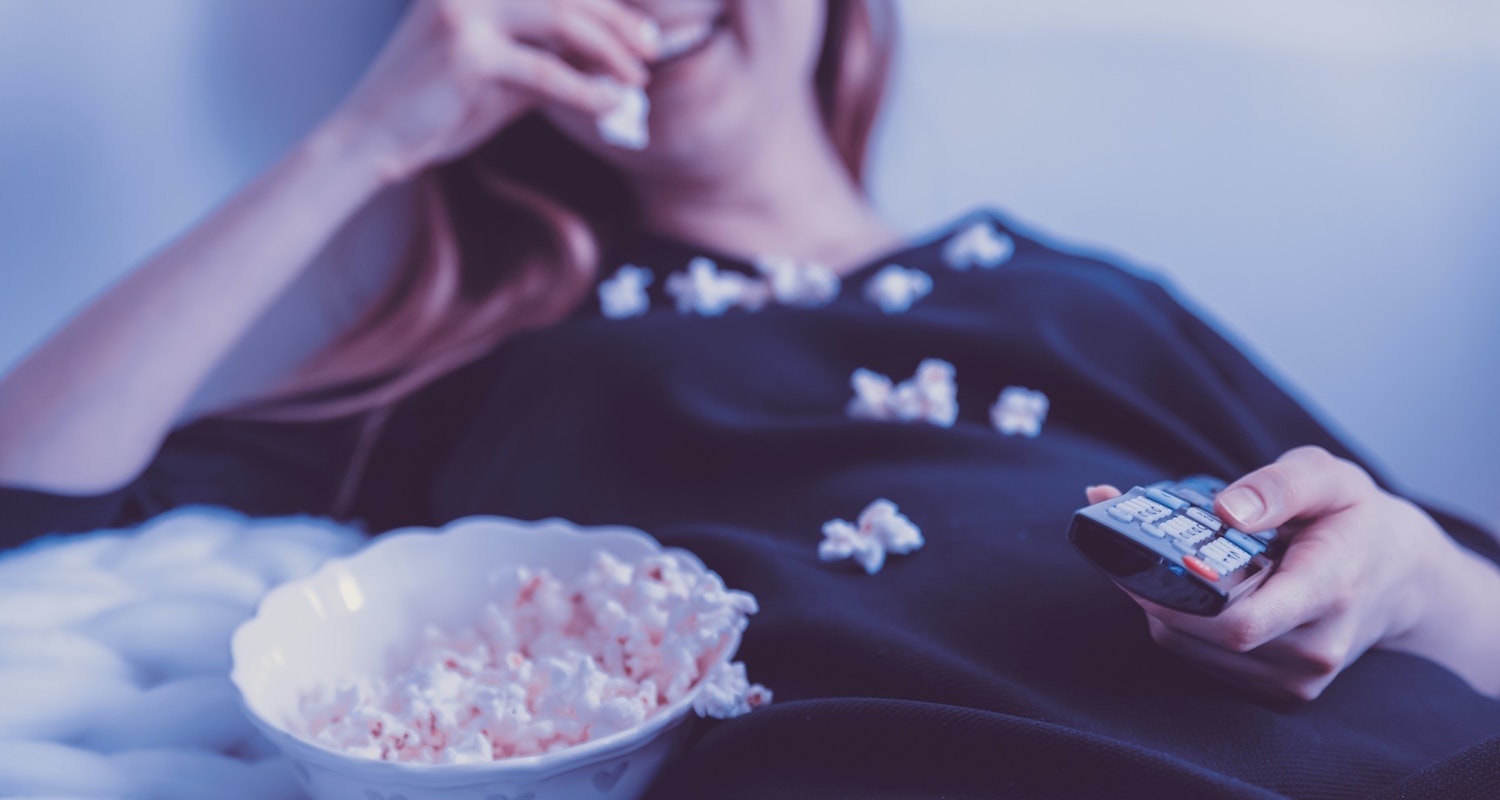 Woman Watching TV on Couch with Popcorn